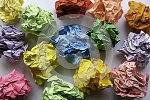 Multicolor crumpled balls over a white background
