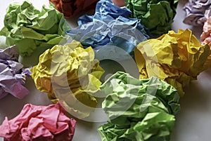 Multicolor crumpled balls over a white background