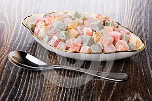 Multicolor cubes of rakhat-lukum in plate and teaspoon on table