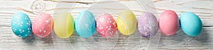 Multicolor Easter eggs on rustic background, space for text
