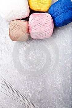 Multicolor knitting ball and needles on grey background. Top view. Copy space. Knitting yarn.