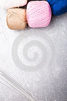 Multicolor knitting ball and needles on grey background. Top view. Copy space. Knitting yarn.