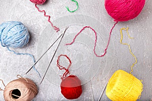 Multicolor knitting ball and needles on grey background. Top view. Copy space. Knitting yarn.