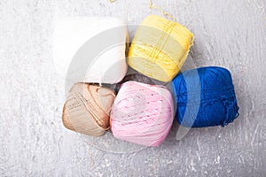 Multicolor knitting ball and needles on grey background. Top view. Copy space. Knitting yarn. Flat lay