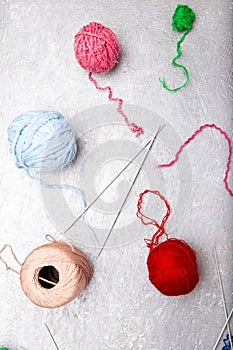 Multicolor knitting ball and needles on grey background. Top view. Copy space. Knitting yarn. Flat lay