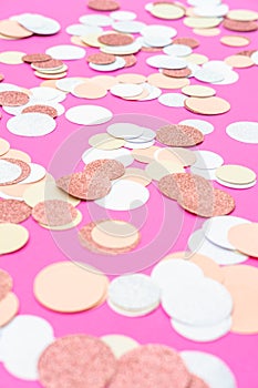 Multicolor pink, gold and white confetti on the bright pink background, holiday celebration backdrop