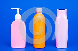 Multicolor plastic containers for liquid toiletries and cosmetic products in row, bottles