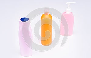 Multicolor plastic refillable liquid toiletry product containers in row, bottles