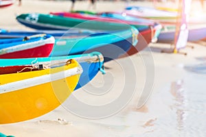 Multicolor rowboat or sea kayaks on beach with copy space.