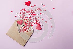 Multicolor sweets sugar candy hearts fly out of craft paper postal envelope. Happy Valentine`s dayconcept.