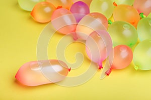 Multicolor water balloons on yellow background