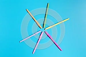 Multicolored ballpoint pens on a blue background. Back to school. Stylish stationery.