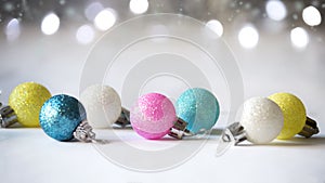 Multicolored balls on the Christmas tree on a light background with bokeh