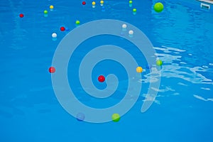 Multicolored balls on the surface of the blue pool.