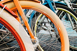 Multicolored bicycle wheels in a row, close-up.