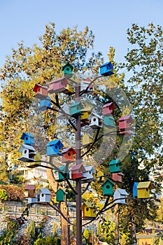 Multicolored birdhouses adorning a metal tree