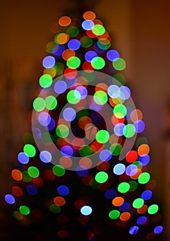 Multicolored blurred silhouette christmas tree bokeh. Abstract background