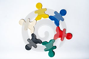 Multicolored bright clay men in a circle isolated on white background, flat lay, top view. The concept of friendship