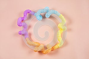 Multicolored bright tubes on light background. Anti-stress sensory figet plastic toy.