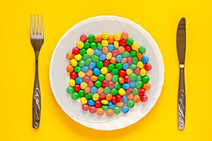 Multicolored candy dragee on a plate