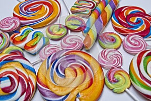 Multicolored candy lollies close ups on white background