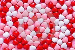 Multicolored candy or Pills in the shape of hearts. Concept Valentine`s Day or Medicine, Pharmacy, Cardiology. Pink background