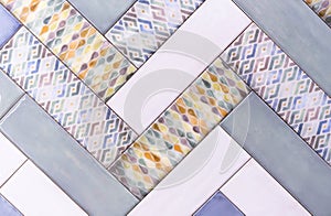 Multicolored ceramic tiles are arranged in a herringbone pattern