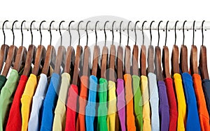 Multicolored clothes on wooden hangers