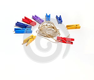 Multicolored clothespins and rope on a white background