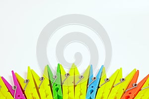 Multicolored clothespins on white background with copy space