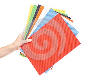 Multicolored corrugated cardboard in a hand