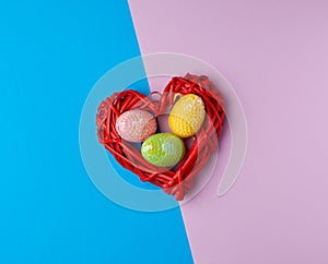 Multicolored decorative Easter eggs decorated with sequins on a blue purple background