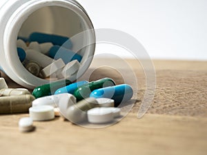 Multicolored of Drug and capsule is on the wooden table. Closeup. We are against drugs anti drugs, cure in container for health.