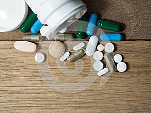 Multicolored of Drug and capsule is on the wooden table. Closeup. We are against drugs anti drugs, cure in container for health.