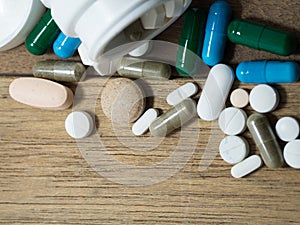 Multicolored of Drug and capsule is on the wooden table. Closeup. We are against drugs anti drugs, cure in container for health.