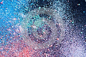 Multicolored dust particles splattered on black background