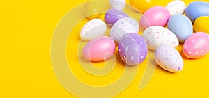 Multicolored easter eggs on yellow background. Easter concept. Top view. Copy space