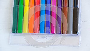 Multicolored felt-tip pens in a transparent package on a white background