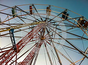 Multicolored ferris wheel over blue sky on a summer afternoon