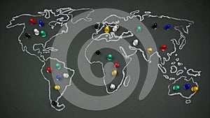 Multicolored figures of people on a world map drawing on blackboard. Population growth. Stop motion