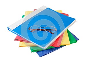 Multicolored folders with glasses on white