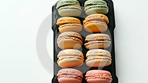 Multicolored french cookies macaron in a special black box on white table top view