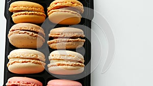 Multicolored french cookies macaron in a special black box on white table top view