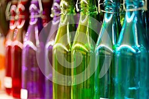 Multicolored glass bottles on the shelf in the store.
