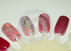 Multicolored glitter nail gel polish on artificial plastic nails.