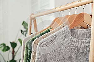 Multicolored handknitted sweaters on hangers