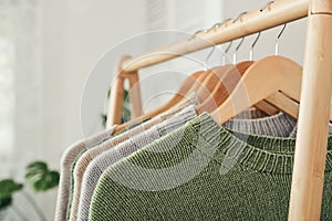Multicolored handknitted sweaters on hangers