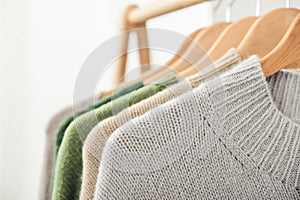 Multicolored handknitted sweaters on hangers