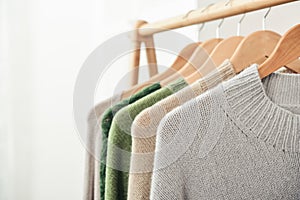 Multicolored handknitted sweaters on hangers