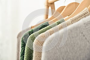 Multicolored handknitted sweaters on hangers